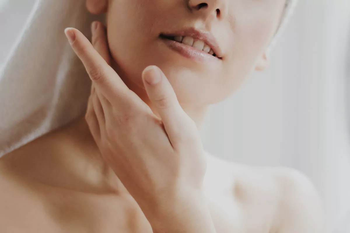 Woman applying oil on skin