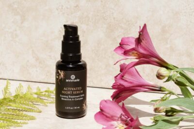 Annmarie Activated Night Serum bottle with pink flowers and green fern leaves.
